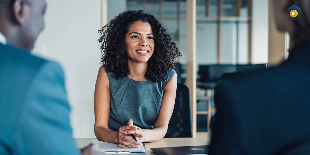 A confident professional woman speaking effectively in a job interview or business meeting, showcasing the communication skills learned from the Business English Course Pack on read4more.com.