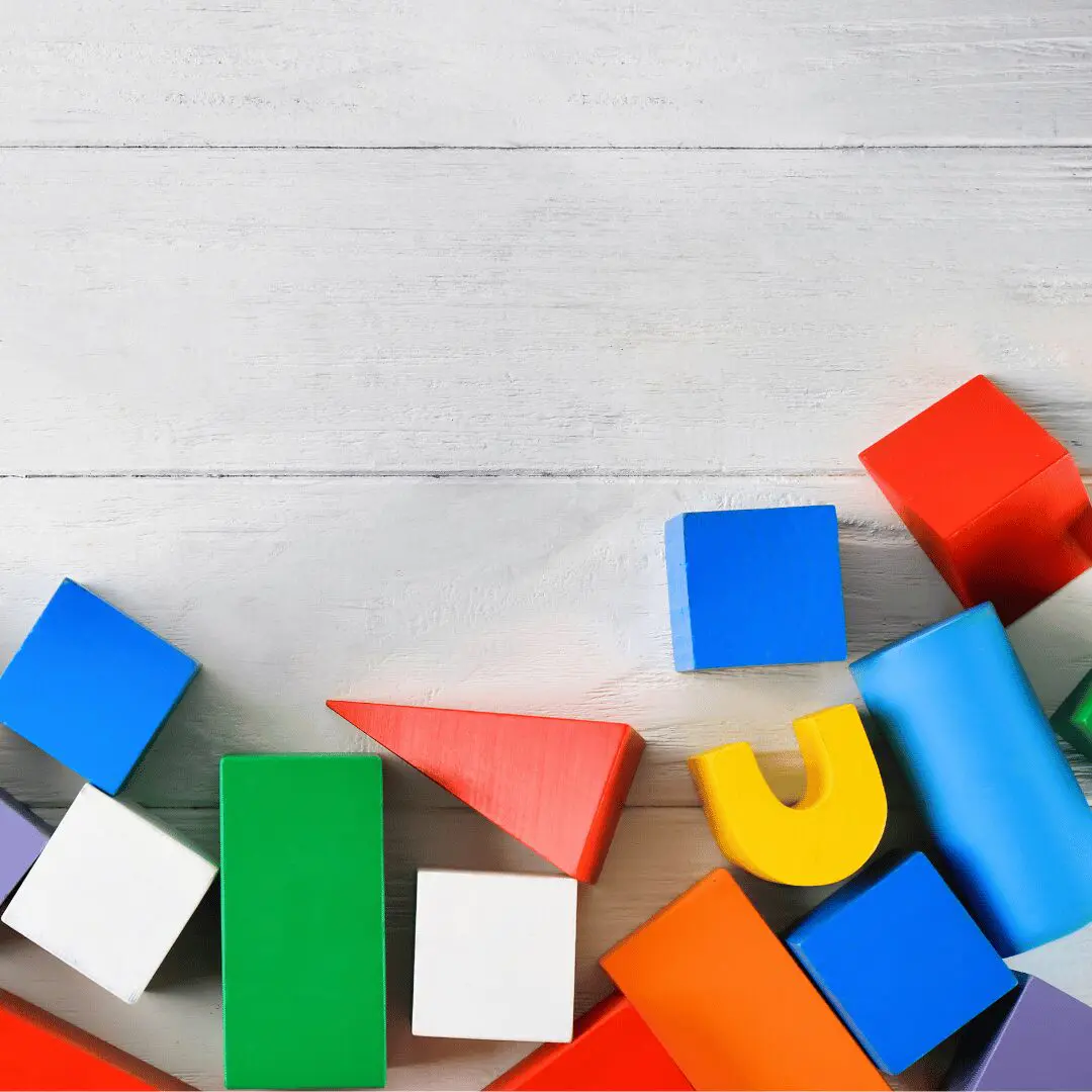 Colorful wooden blocks in various shapes (square, triangle, rectangle) on a white background, with the text "Beginner - A2 Level General Conversation Course". This is the featured image for a read4more.com lesson on how to describe shapes in English.