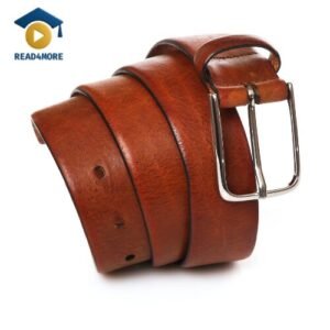 A high-quality studio photo of a coiled brown leather belt with a silver buckle, used to illustrate the material 'leather' for a beginner English vocabulary lesson on read4more.com.