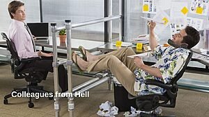 Two office workers sit at their desks; one appears frustrated while the other lounges casually with feet up and papers scattered around, representing workplace conflict.