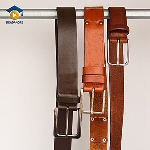 Three leather belts hanging on a rack, visually defining the English vocabulary word for a strap worn around the waist for the Read4More online glossary.