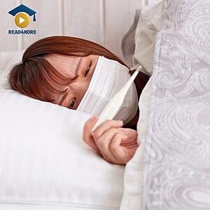 A sick woman lying in bed wearing a mask and holding a thermometer, visually defining the English vocabulary word "fever" (high body temperature) for the Read4More online glossary.