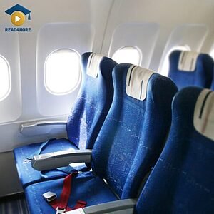 A row of empty blue airplane seats next to cabin windows, visually defining the English vocabulary word for a place to sit on a plane.